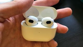 어두운 책상 옆에 ​​있는 Apple AirPods 3