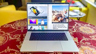 두 개의 웹 페이지가 나란히 표시된 테이블에 놓인 MacBook Pro 2021(16인치)