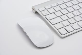 흰색 표면에 있는 흰색 및 회색 Apple Magic Keyboard 옆에 있는 흰색 Apple Magic Mouse