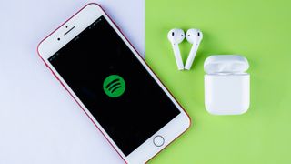 한 쌍의 airpod 옆에 있는 iPhone의 spotify