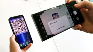 iPhone에서 Android로 Wi-Fi 암호를 공유하는 방법에 대한 기사를 나타내는 iPhone 13 Pro Max에서 Wi-Fi QR 코드를 스캔하는 Samsung Galaxy S22 Ultra