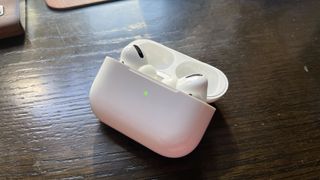 AirPods Pro가 내부에 있고 녹색 표시등이 켜진 상태로 열린 AirPods Pro 케이스