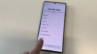 WhatsApp 섹션을 가리키는 손가락이 있는 Move to iOS 앱의 데이터 전송 화면