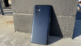 벽에 기대어 있는 OnePlus 9의 뒷면