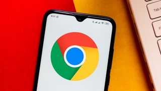 주황색과 빨간색 표면에 놓인 Android 스마트폰에 표시되는 Google Chrome 로고