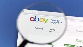 로고가 강조 표시된 돋보기가 있는 eBay 홈페이지를 보여주는 이미지