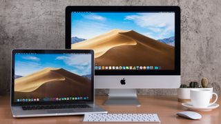 홈 오피스의 책상에 있는 Apple MacBook 및 Apple iMac