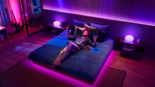 Philips Hue 조명이 음악에 맞춰 춤을 추며 Spotify를 들으면서 침대에 누워 있는 남자