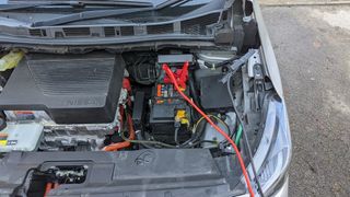 12v 배터리에 연결된 점퍼 케이블이 있는 Nissan 리프