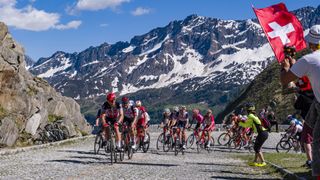 눈 덮인 알프스를 배경으로 Tour de Suisse의 펠레톤에 탑승한 사이클 선수