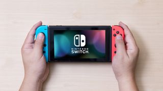 Nintendo Switch에서 다크 모드를 활성화하는 방법 - Nintendo Switch를 들고 있는 남자