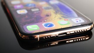 iPhone 스피커 청소 방법을 시연할 준비가 된 스피커를 보여주는 iPhone의 하단부